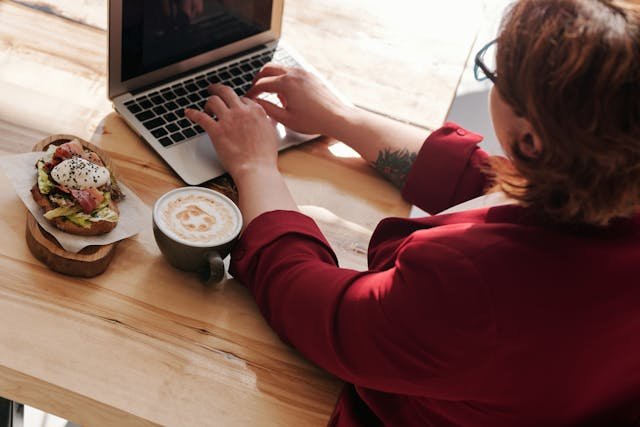 freelancer sitting on a chair typing on her laptop
