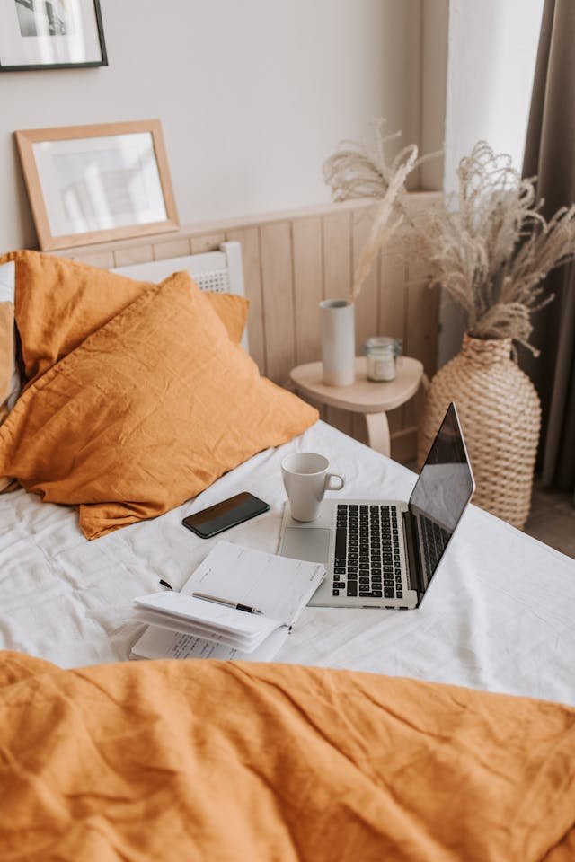 mug and laptop on the bed